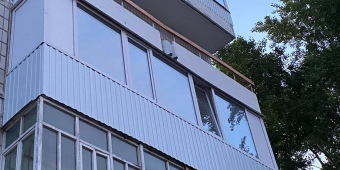 Отделка балкона белым сайдингом и замена холодного остекления на теплое (поворотно откидная конструкция). Дополнительно были проведены работы по утеплению пола.